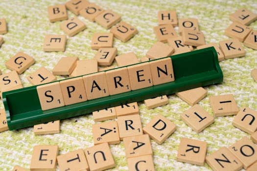 Close-up of Scrabble tiles spelling 'Sparen' on a green tile holder.