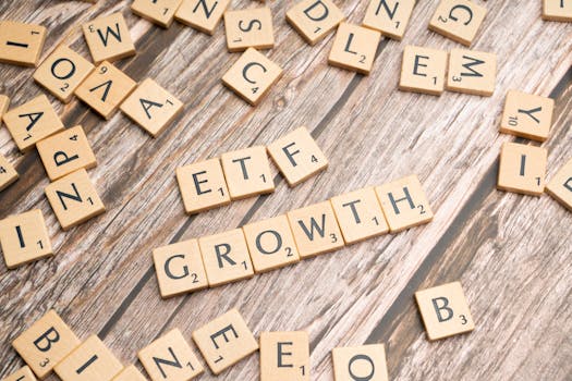 Wooden tiles spelling ETF growth on a wooden surface, symbolizing investment strategy.